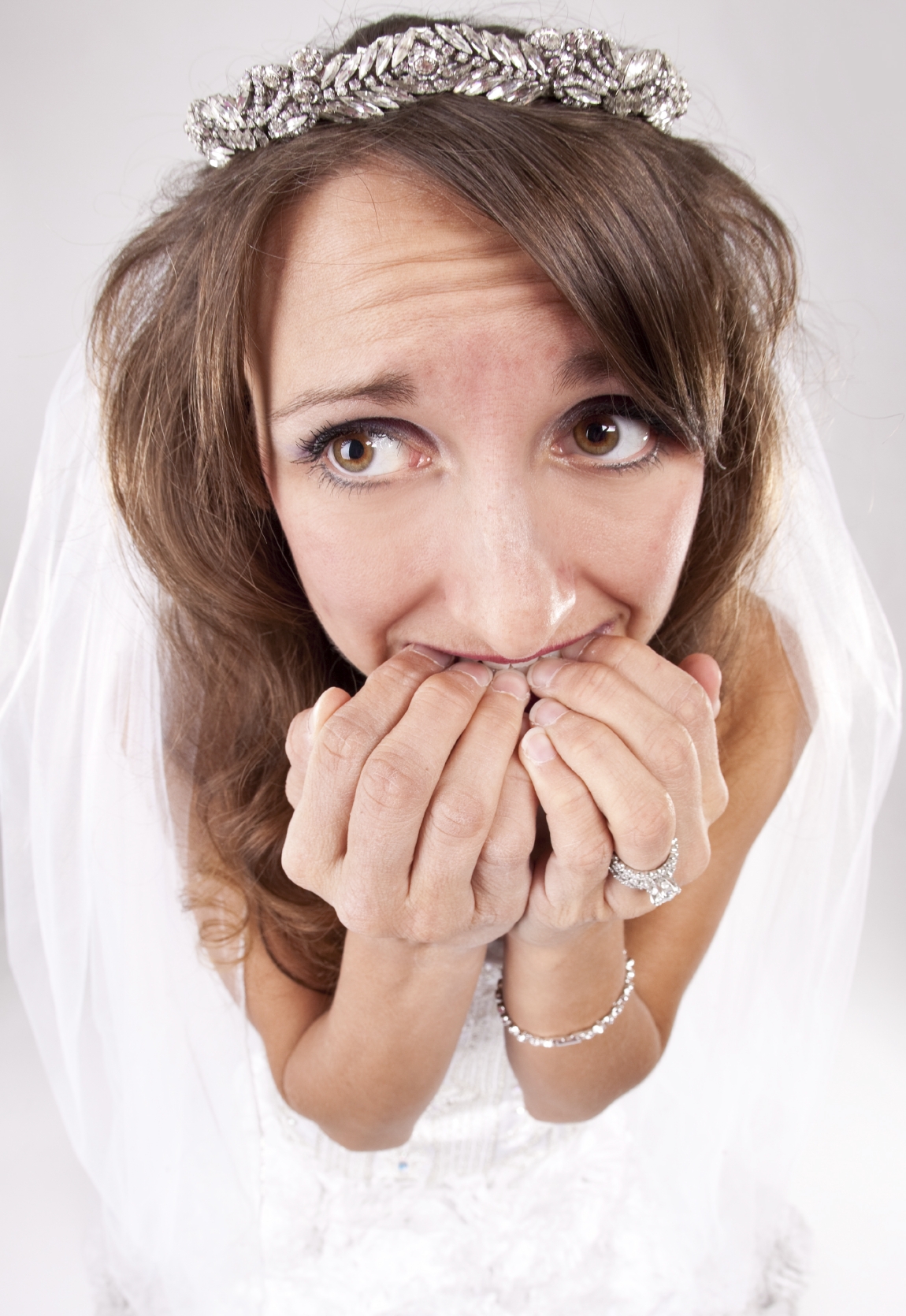 A nervous bride biting her fingernails.